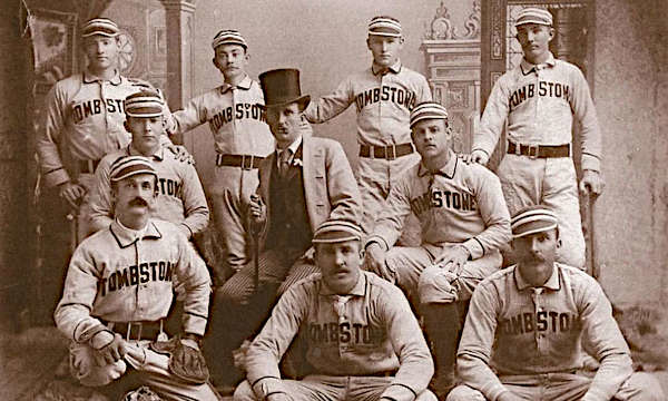 Vintage sepia photograph of the Tombstone baseball team, circa late 1800s, featuring nine players in uniforms and a man in formal attire with a top hat.