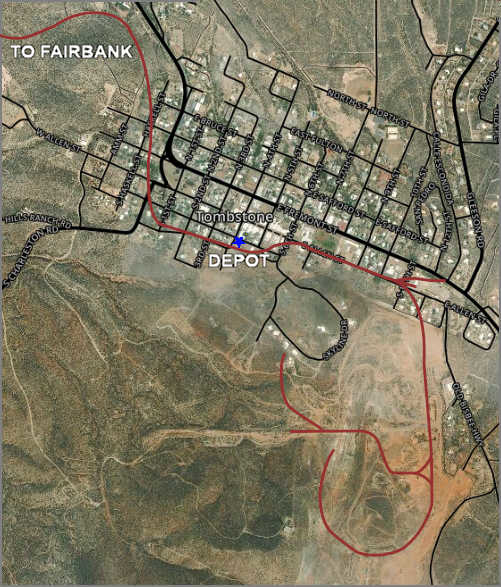 Aerial map of Tombstone, Arizona showing the town layout with streets and buildings. A red line outlines the old railroad route that circles through and around the town. The map labels key locations like 